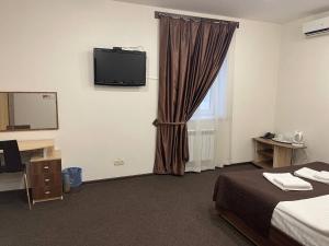 een hotelkamer met een bed en een televisie aan de muur bij Нивки плаза апартаменти in Kiev
