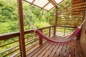 una hamaca en el porche de una casa en un árbol en Utopia Bluff Beach Off Grid Jungle Retreat By The Sea, en Bocas Town