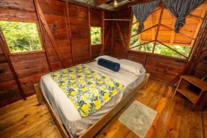Un dormitorio con una cama en una cabaña de madera. en Utopia Bluff Beach Off Grid Jungle Retreat By The Sea, en Bocas Town