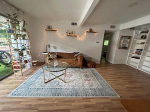Una sala de estar con un sofá y una mesa de cristal. en Ensuite Private Room, en Austin