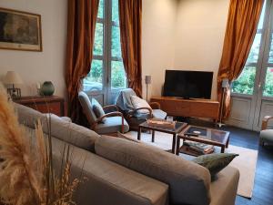 un salon avec un canapé et une télévision dans l'établissement villa Droizy, à Droizy