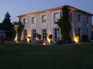 - un grand bâtiment blanc avec des lumières dans la cour dans l'établissement villa Droizy, à Droizy