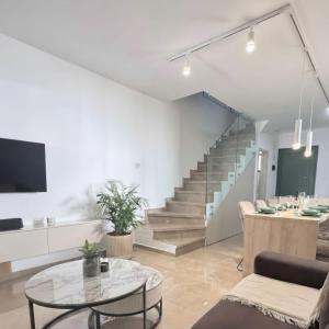 un salon avec un escalier et une table dans l'établissement Luxury Beach Villa 2 min Walk to Sea & Airport, à Meneou