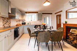 Draytonにある3 Bedroom House that Sleeps 6のキッチン(テーブル、椅子、暖炉付)