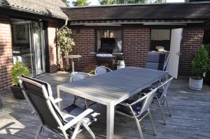 a table and chairs on a patio with a grill at Flygarevägen in Höllviken