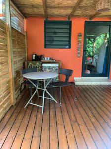 a patio with a table and chairs on a deck at Les Manguiers in Deshaies