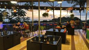 a group of people sitting at tables in a restaurant at Mountain Top Park Hotel in Quepos