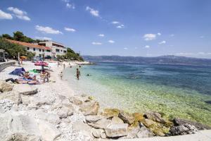 a group of people on a beach near the water at Apartament Skoko in Slatine