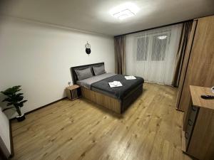 a bedroom with a bed and a wooden floor at Central Studio in Piteşti