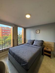 a bedroom with a large bed and a balcony at Hostelfc Movistar57 in Bogotá