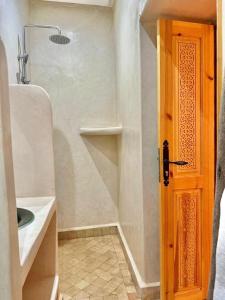 a bathroom with a shower and a sink and a door at Villa Momo Kaouki in Essaouira