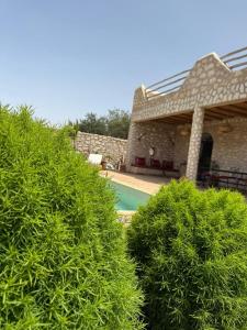 a house with a swimming pool and some bushes at Villa Momo Kaouki in Essaouira +8 photos