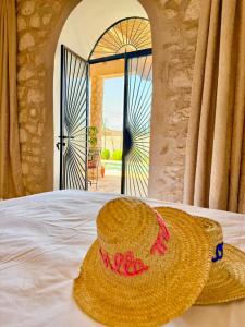 a straw hat sitting on a bed in front of a door at Villa Momo Kaouki in Essaouira