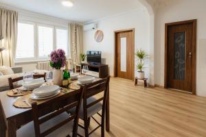 a dining room and living room with a table and chairs at BNB Sklenarova Apartment with Balcony in Trnávka