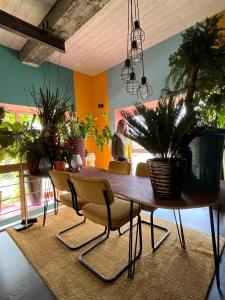 a dining room with a table with chairs and plants at Plantkot, a cozy apartment full of plants of tinykot in Keerselaar