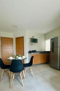 een keuken met een tafel, stoelen en een koelkast bij Apartamento Completo aconchegante- Fácil acesso ao Aeroporto e a COP-30 in Belém