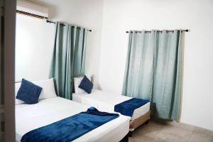 two beds in a room with green curtains at Gated Property Family Ready walk to restaurants AC in Saint Thomas