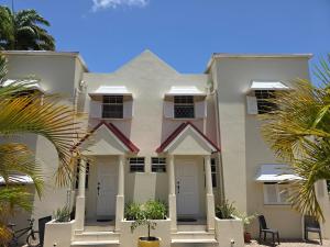 a white house with palm trees in front of it at Gated Property Family Ready walk to restaurants AC in Saint Thomas