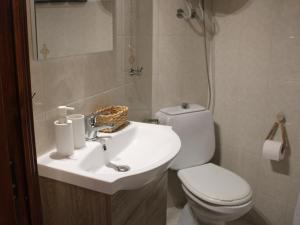 a bathroom with a white sink and a toilet at La Piazzetta Apartment in Pietralunga +5 photos