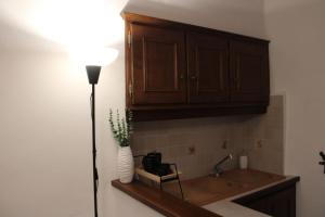a kitchen with a sink and a wooden cabinet at La Piazzetta Apartment in Pietralunga