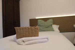 a bed with two towels and a basket on it at La Piazzetta Apartment in Pietralunga