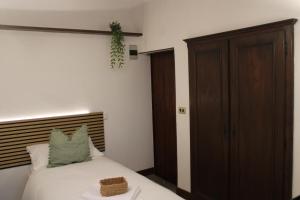 a bedroom with a bed and a wooden cabinet at La Piazzetta Apartment in Pietralunga +5 photos