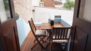 a wooden table and two chairs on a balcony at Furadouro Surf Camp (Studios) in Ovar