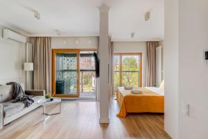 ein Schlafzimmer mit einem Bett und einer Couch in einem Zimmer in der Unterkunft Luxury 2-room apartment with a beautiful city view in Warschau