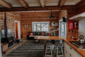 a log cabin kitchen and living room with a couch at Alpine Haven, Peaceful , Stunning Views - ML21396 in Mt Lyford +15 photos