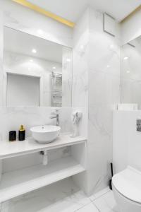 ein weißes Badezimmer mit Waschbecken und Toilette in der Unterkunft Luxury 2-room apartment with a beautiful city view in Warschau