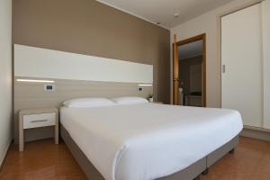 a bedroom with a large white bed and a mirror at Residence all'Adige in Verona +67 photos