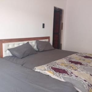 a bed with gray sheets and pillows on it at Sangam guest house in Prayagraj