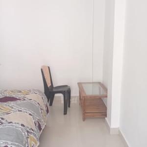 a bedroom with a bed and a chair and a table at Sangam guest house in Prayagraj