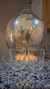 two glasses sitting on a table with a glass vase at Christmas Arabic Escape Roof Terrace 3 Bedroom Luxury Appartment Superb Location and just 15 mins from El Gouna in Hurghada