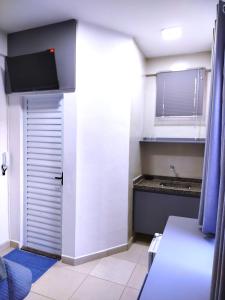 a small kitchen with a door and a sink at Vila Del Rei - Flat no Centro de São João Del rei in São João del Rei