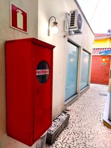 a red box on the side of a building at Vila Del Rei - Flat no Centro de São João Del rei in São João del Rei