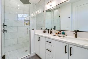 a white bathroom with a shower and a sink at Chic Austin House with Spacious Backyard and Hammock in Austin +28 photos