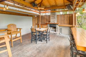 een eetkamer met een tafel en stoelen en een open haard bij TroutFest Anglers Retreat on White River with Deck in Cotter