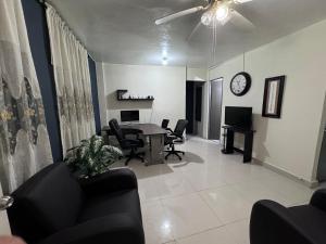 a living room with a table and chairs and a clock at Excelente apartamento para 4 personas in Monterrey