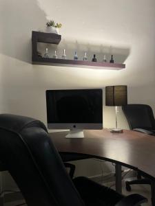 an office with a desk with a monitor and two chairs at Excelente apartamento para 4 personas in Monterrey +2 photos