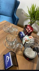 a wooden table with glass bowls on top of it at Stojanovski Apartments in Kumanovo +35 photos