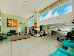 a large lobby with blue chairs and a large window at Ponta Negra Beach Praiano Flat in Natal