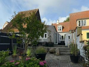 a home with a courtyard with potted plants at Town House With Sea View In Historic Ærøskøbing in Ærøskøbing