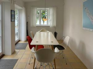 a dining room with a white table and chairs at Town House With Sea View In Historic Ærøskøbing in Ærøskøbing