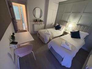 a hotel room with two beds and a mirror at Court Studio Apartment in Cardiff