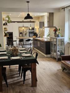 a kitchen and living room with a table and chairs at Le Refuge Aristide - Cozy - 4ch - Grand parking gratuit in Cravanche +24 photos