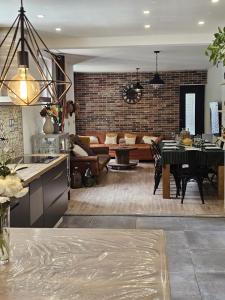 a kitchen and living room with a table and a couch at Le Refuge Aristide - Cozy - 4ch - Grand parking gratuit in Cravanche