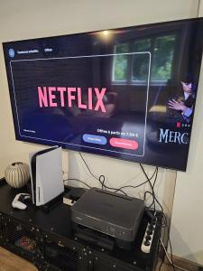 a television with a netflix sign on top of a desk at Le Refuge Aristide - Cozy - 4ch - Grand parking gratuit in Cravanche