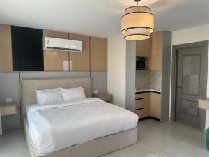 a bedroom with a white bed and a kitchen at Kaza home hotel in Cairo