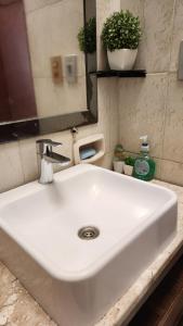 a white sink in a bathroom with a mirror at Sala en Casa Familiar para 2 personas in Asuncion